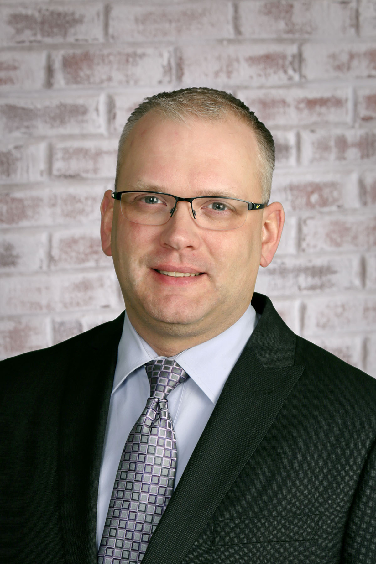 a man wearing glasses and a suit