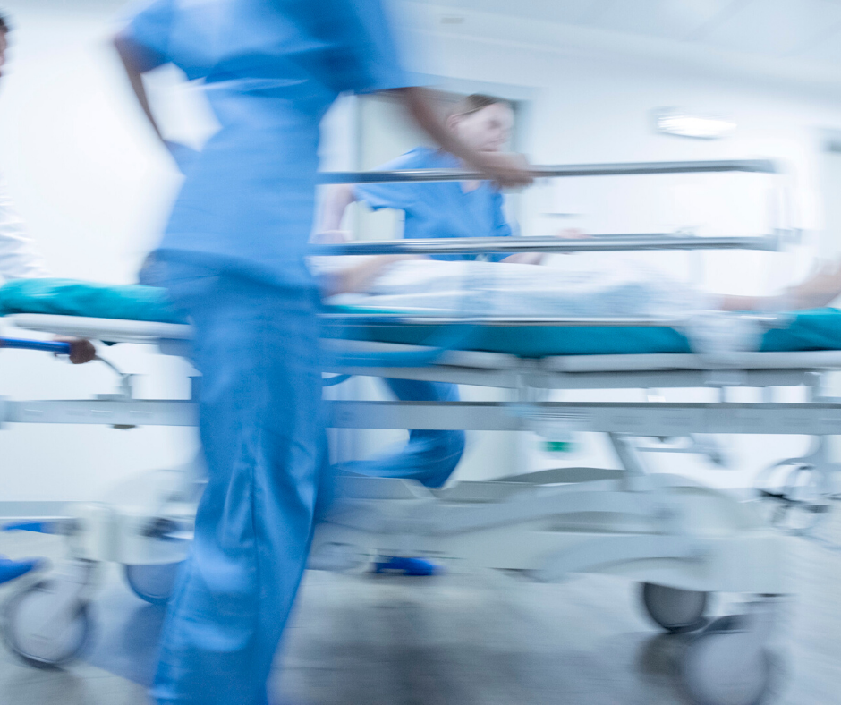 a blurry picture of two nurses running with a patient laying in a hospital gurney